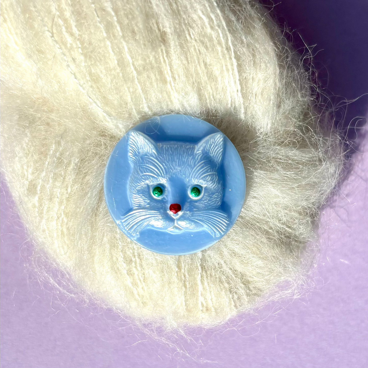 katte knap i blå med grønne øjne