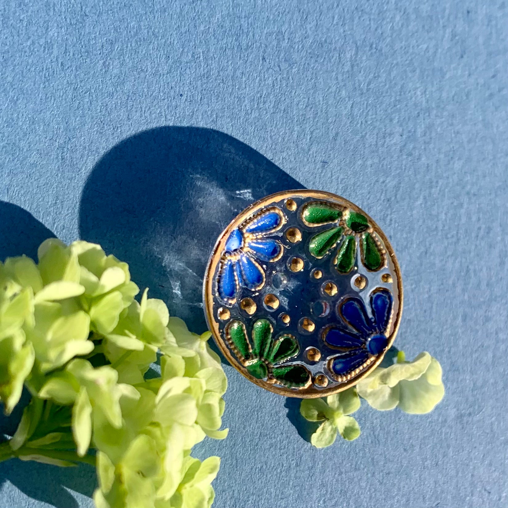 glasknap 2 huller kamelia knap i blå, grøn med guld detaljer 18mm 