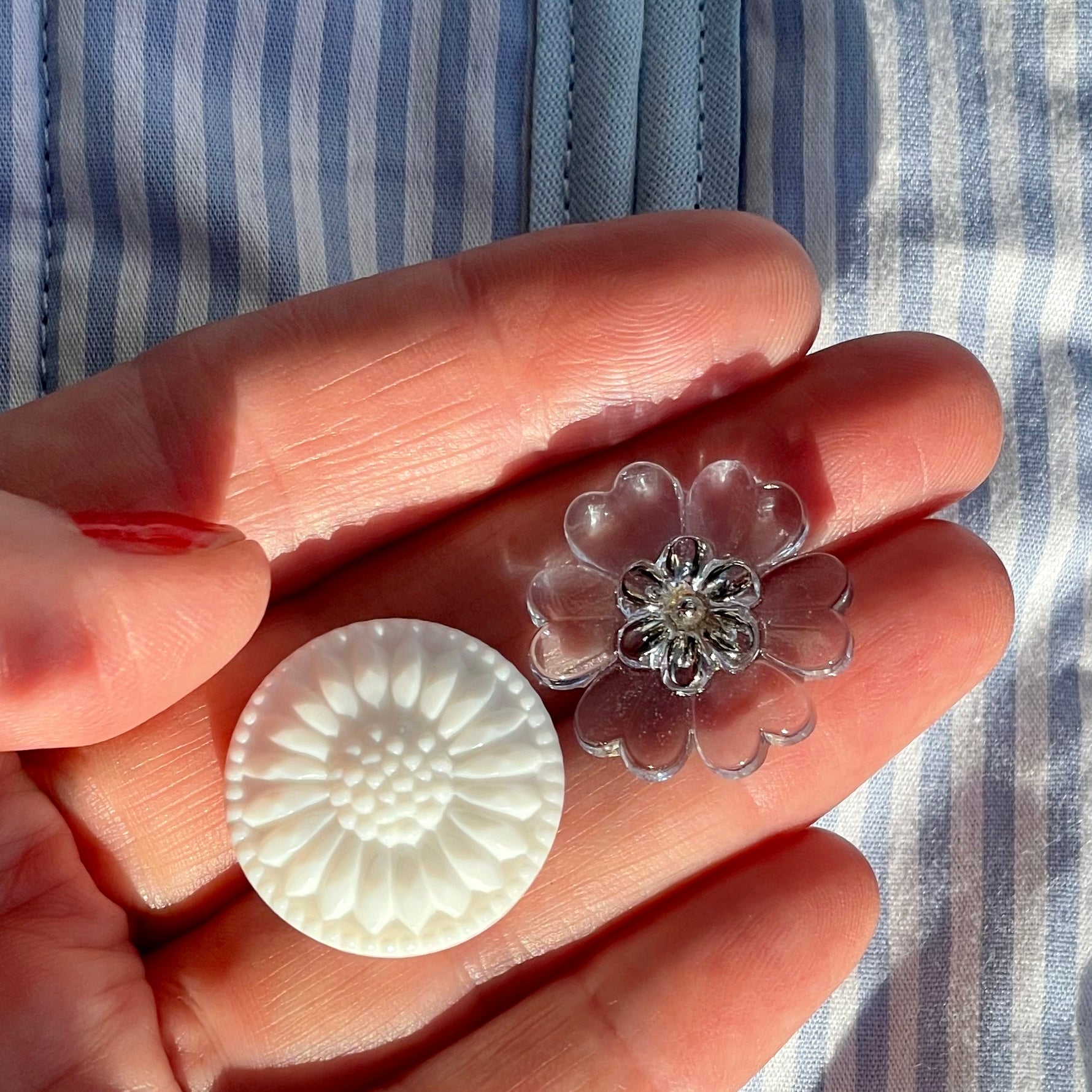 to blomster knapper i glas liggende i en hånd knapperne er fra finedetail.dk